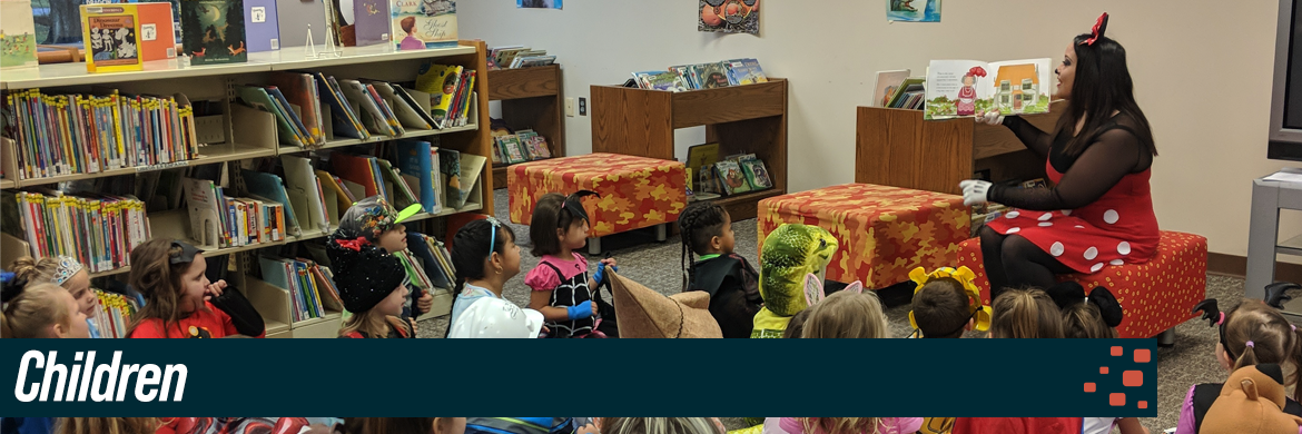 Children header image showing a group of kids during storytime being read to by woman dressed as minnie mouse