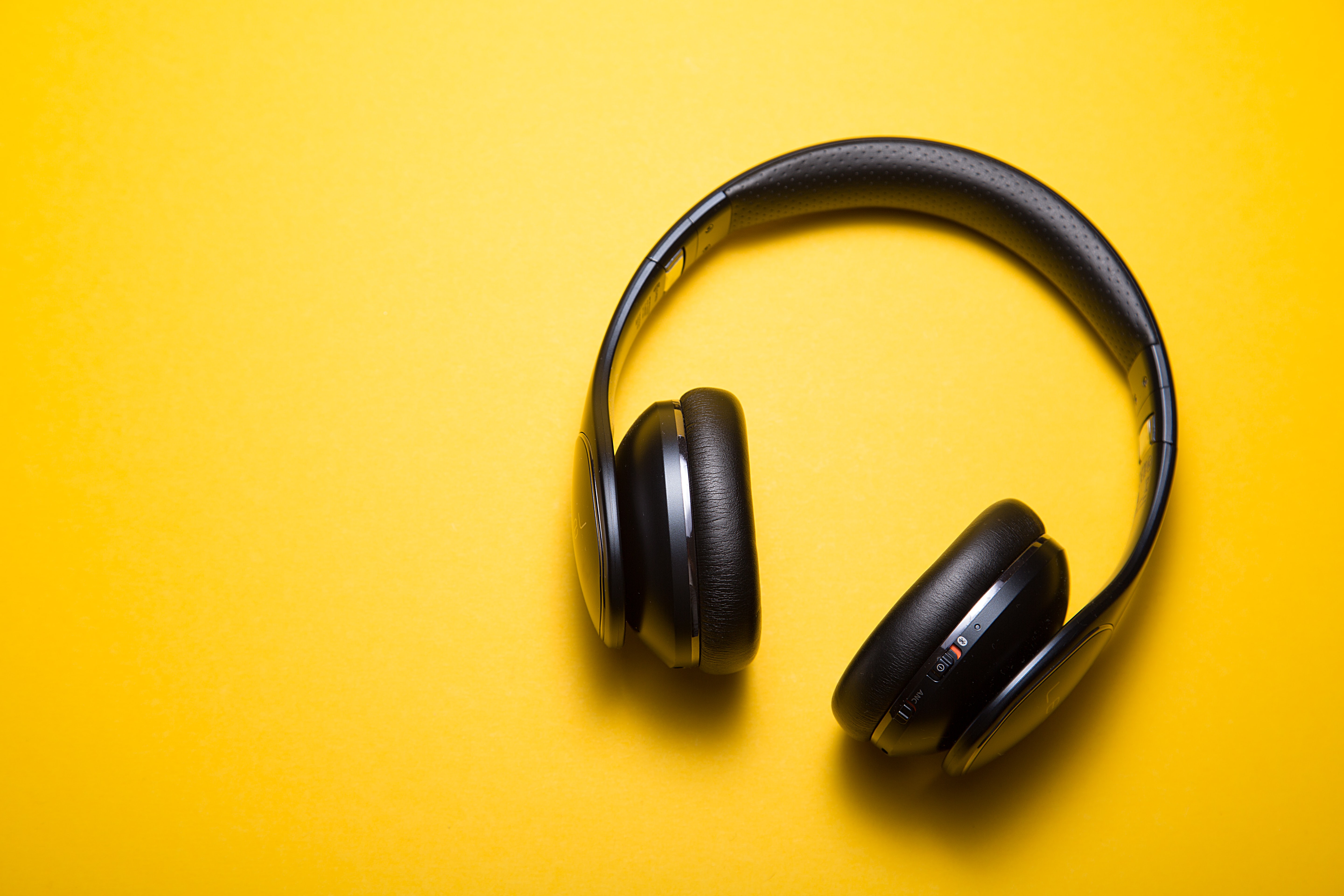 Pair of headphones on yellow background.