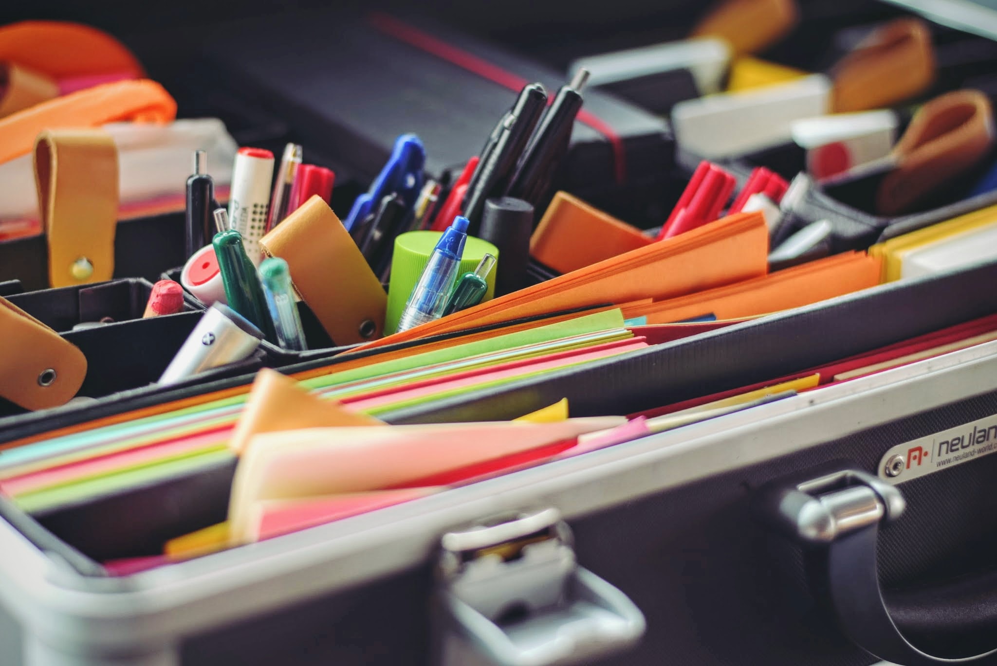 Photo of the inside of a briefcase, filled with office supplies.