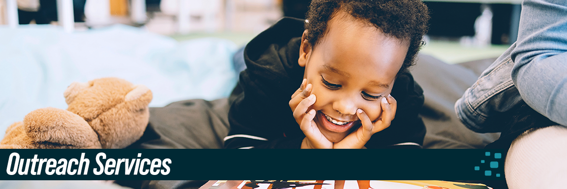 Young boy smiling and reading