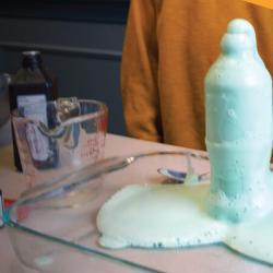 A bottle overflowing with dish soap, water, hydrogen peroxide, and active dry yeast. 