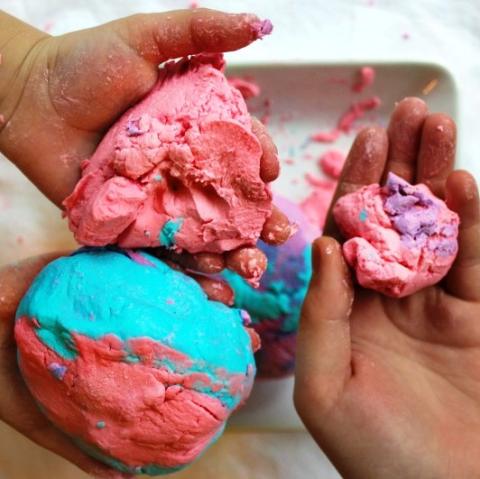 Hands holding pink and blue squishy soap