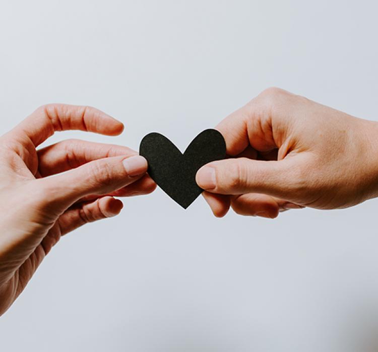 Two hands sharing a heart 